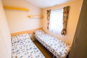 A bed or beds in a room at MP694 - Camber Sands - Sleeps 8