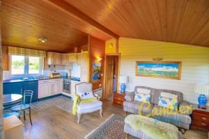 a living room with a couch and a kitchen at Tore Petty - Romantic lodge - spa bath and sauna in Brookland