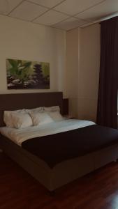 1 dormitorio con 1 cama grande con almohadas blancas en Best Guest Vandrarhem, en Norrköping