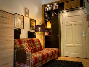 a living room with a couch and a book shelf at Mini-Appartements am Burgberg in Bad Harzburg