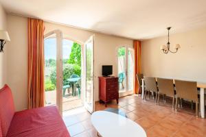 a living room with a table and chairs and a television at Les Maisons de Pont Royal en Provence - maeva Home - Maison 4 Pièces 8 Personnes climatisée - Confort MAE-0094 in Mallemort