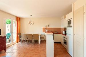 a kitchen with a table and chairs in a room at Les Maisons de Pont Royal en Provence - maeva Home - Maison 4 Pièces 8 Personnes climatisée - Confort MAE-0094 in Mallemort