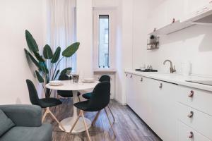 een keuken met een tafel en stoelen en een wastafel bij Central wonderful flat Repubblica Central station in Milaan