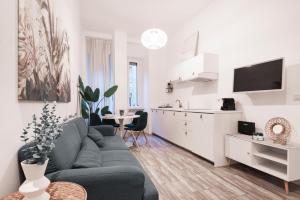 een woonkamer met een bank en een keuken bij Central wonderful flat Repubblica Central station in Milaan