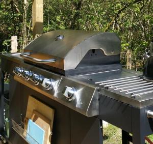 a barbecue grill with a wooden top and a grill at Snowdonia Shepherds' Huts in Conwy