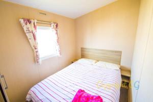 a small bedroom with a bed and a window at SP84 - Camber Sands Holiday Park - 3 Bedroom - Sleeps 8 - Private Parking in Camber