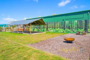 a playground with a green building and a bench at SP84 - Camber Sands Holiday Park - 3 Bedroom - Sleeps 8 - Private Parking in Camber