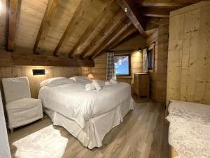 ein Schlafzimmer mit einem Bett und einem Stuhl in einer Hütte in der Unterkunft Chalet Des Encombres - Pièces 314 in Saint-Martin-de-Belleville