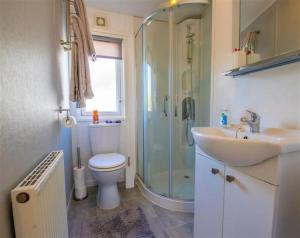 Un baño con ducha, inodoro y lavabo. en SBL19 - Parkdean Resorts, Camber Sands, en Camber
