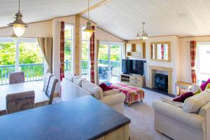 sala de estar con sofás, mesa y chimenea en MP778 - 2B Lodge - Parkdean - Camber Sands, en Camber