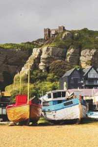 tres barcos sentados en la arena en la playa en 35 Redwood - Beauport Park, Hastings, en Hastings