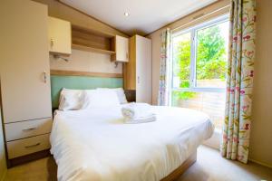 a bedroom with a large white bed with a window at Hazel Glen 3 - Beauport Park - Hastings in Hastings