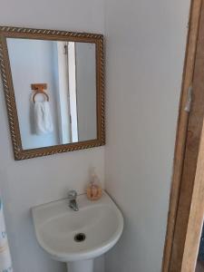 y baño con lavabo blanco y espejo. en Cabaña con Vista al mar Playa grande Quintay, en Casablanca