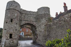 un antiguo castillo de piedra con un arco en una calle en The Gazebo in Winchelsea, en Winchelsea