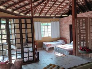 Habitación con dormitorio, cama y ventanas. en Chácara pausa vital, en Mairiporã