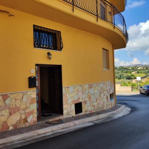 un edificio amarillo con puerta y balcón en Panoramico WiFi TV Centro Storico, en Casteldaccia