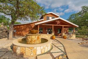 a home with a fountain in front of a building at Sun Outdoors Lake Travis in Hudson Bend