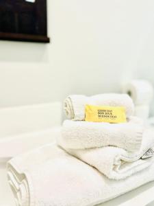 une pile de serviettes assises sur un comptoir dans la salle de bains dans l'établissement Incredible Private Room with King Bed and Bathroom, à Lithonia