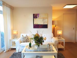 uma sala de estar com um sofá branco e uma mesa em fewo1846 - Residence Museumsberg - luxuriöse Wohnung mit 2 Schlafzimmern und 2 Bädern em Flensburg