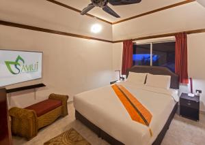 a hotel room with a bed and a tv at Samui Little Garden Resort in Chaweng