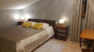 a bedroom with a bed with two yellow pillows at Rooms Marko Polo in Zadar