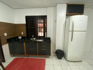 uma cozinha com um frigorífico branco e um tapete vermelho em Apartamento Principado em Torres