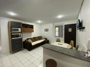 a living room with a couch and a kitchen at Apartamento Principado in Torres