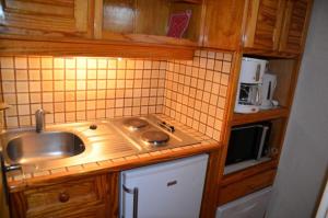 eine kleine Küche mit einer Spüle und einer Mikrowelle in der Unterkunft Résidence Jetay - 2 Pièces pour 6 Personnes 654 in Les Menuires