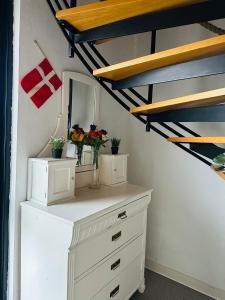 een kamer met een dressoir met bloemen erop bij 5min walk to LEGO House - two bedrooms on Loft floor with Balcony * with garden in Billund