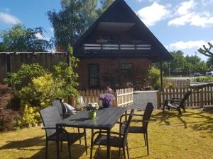 een tafel en stoelen in een tuin met een huis bij 5min walk to LEGO House - two bedrooms on Loft floor with Balcony * with garden in Billund