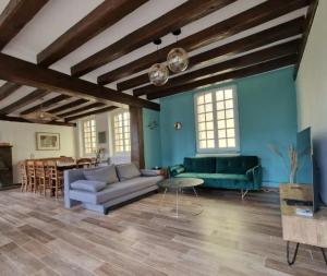 a living room with a couch and a table at Maison spacieuse - Piscine - Jardin 