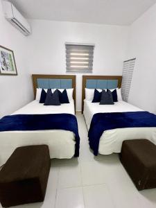 two beds in a room with blue and white at Janer House at San Juan in San Juan