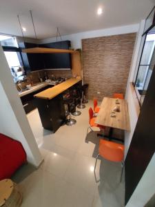 una cocina con mesa de madera y sillas naranjas en Hotel Kallma Adventures en Ica