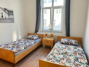 1 dormitorio con 2 camas y ventana en Gemütliche Retro Wohnung, en Bremerhaven
