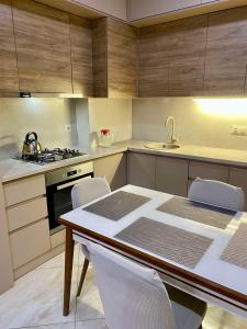 een keuken met een tafel en stoelen en een wastafel bij New & Fully Equipped Apartment in Gldani in Tbilisi City