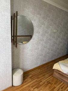 een slaapkamer met een spiegel, een bed en een houten vloer bij New & Fully Equipped Apartment in Gldani in Tbilisi City