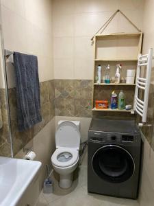 een badkamer met een toilet en een wasmachine bij New & Fully Equipped Apartment in Gldani in Tbilisi City