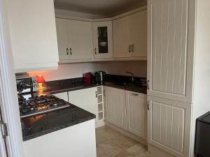 a kitchen with white cabinets and a stove top oven at Ardmore Village Family Home in Ardmore