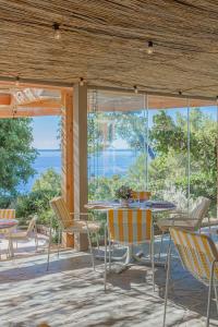a patio with tables and chairs and a view of the ocean at Résidence hôtelière Le Provençal à Giens - Bord de mer in Hyères