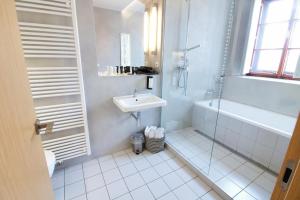 a white bathroom with a sink and a shower at Hotel 100 in Pardubice +36 photos