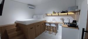 Cosy studio with all amenities في غراند بايَ: مطبخ صغير مع كونتر وكراسي فيه