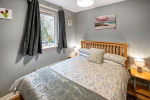 a bedroom with a bed and a window at Argyll Apartments - Drimvargie Terrace, Oban in Oban
