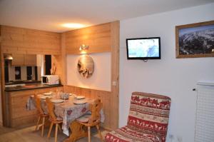ein Esszimmer mit einem Tisch und einer Küche in der Unterkunft Résidence Chaviere - 2 Pièces pour 5 Personnes 924 in Les Menuires