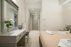 a bedroom with a bed and a sink and a mirror at Parnassos Delphi Hotel in Delphi