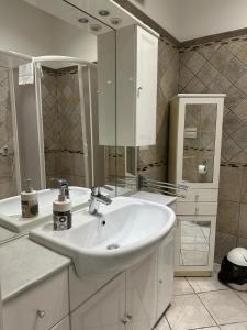 a white bathroom with a sink and a mirror at Zeffirino Apartments in Sanremo