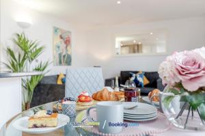 una mesa con un plato de comida y un jarrón de flores en Windsor, 2 Bedroom Apartment By Sentinel Living Short Lets & Serviced Accommodation Windsor Ascot Maidenhead With Free WiFi, en Windsor