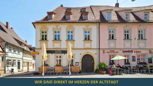 a building in a town with tables and chairs at NEU SandAPART32 - 3 tolle FeWos von 1-8 Pers mitten in der Altstadt in Bamberg