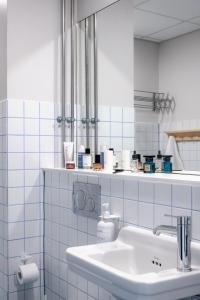 a white bathroom with a sink and a mirror at Beach Trail apartments by Daniel&Jacob's in Copenhagen