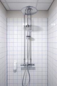 y baño con ducha y azulejos blancos. en Beach Trail apartments by Daniel&Jacob's, en Copenhague