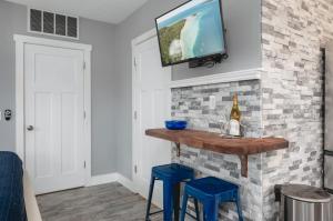 a living room with a tv on a brick wall at Studio TC Close to Downtown Beaches and Wineries in Traverse City